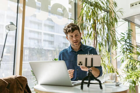 Young businessman discussing on video call through smart phone at cafe stock photo