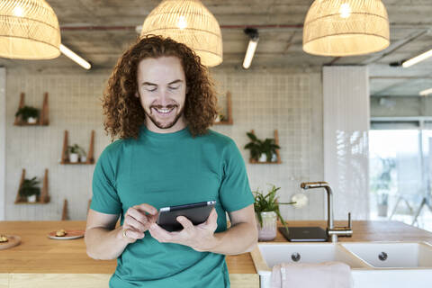 Handsome man using digital tablet while standing at studio apartment stock photo