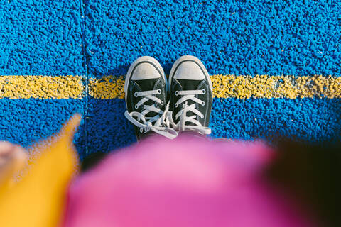 Girl standing on marking at blue sports court stock photo