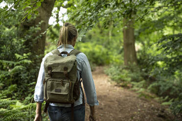 Senior woman walking with backpack in forest - PMF01478