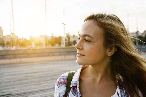 Thoughtful attractive woman looking away during sunset stock photo