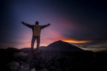 Mann mit ausgestreckten Armen auf einem Berg im Nationalpark El Teide, Teneriffa, Spanien - SIPF02213