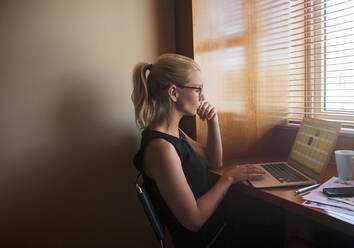 Young woman working on laptop at home - AJOF00469