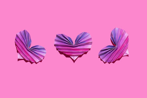 Studioaufnahme von drei rosa und lila Origami-Herzen - GEMF04329