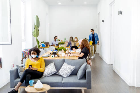 Employees wearing face mask while working at office - MPPF01190