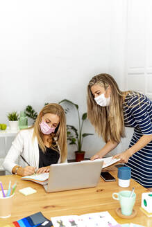Business people wearing face mask working at office - MPPF01202
