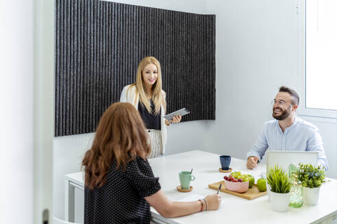 Male and female coworkers working while sitting at office - MPPF01240