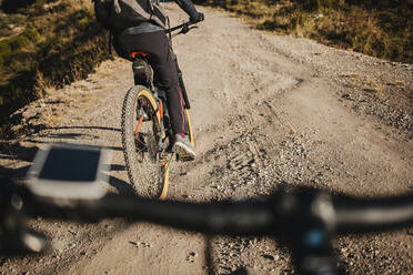 Mountain biker riding bicycle on mountain road at Somiedo Natural Park, Spain - DMGF00241