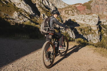 Lächelnde Frau auf elektrischem Mountainbike im Naturpark Somiedo, Spanien - DMGF00245