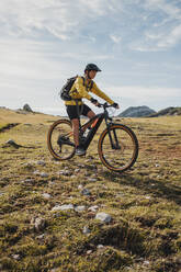 Mountainbikerin fährt Fahrrad auf einem Berg im Naturpark Somiedo, Spanien - DMGF00253