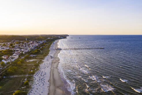 Germany, Mecklenburg-Western Pomerania, Heringsdorf, Aerial view of coastal town at sunset with clear line of horizon in background - WDF06360