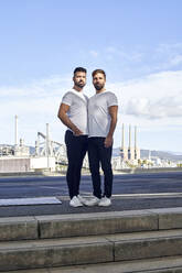 Selbstbewusstes schwules Paar steht auf einer Brücke gegen den Himmel - VEGF03089