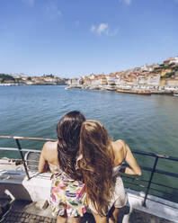 Young female friends looking at Douro River during weekend, Porto, Portugal - RSGF00393