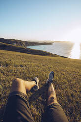 Man relaxing on hill against sky at Mirador de La Providencia, Gijon, Spain - RSGF00407