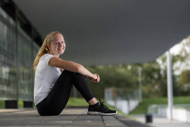 Junge Sportlerin beim Ausruhen am Trainingsplatz - STSF02645