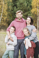 Glücklicher Mann und Frau mit Kindern auf einem Feld am Wochenende - EYAF01418