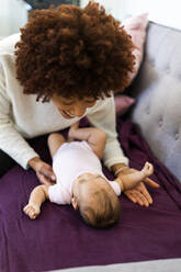 Frau sieht Baby auf Sofa im Wohnzimmer liegen - GIOF09513