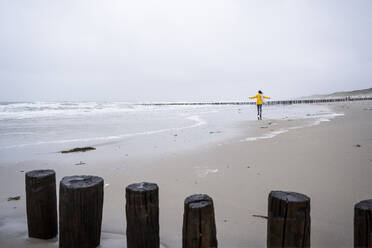 Sorglose Frau, die am Strand gegen den Himmel spazieren geht - UUF22054