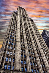 Tall skyscraper against orange sky during sunset, New York, USA - HOHF01433