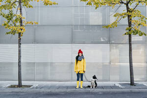 Lächelnde Frau mit Hund auf einem Fußweg im Herbst - EBBF01195