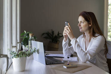 Psychologist using mobile phone while sitting at home - AFVF07457