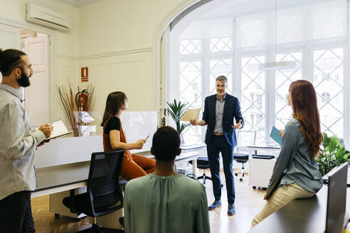 Businessman discussing strategy with colleagues in office - JRFF04817