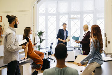 Geschäftsleute besprechen Strategien mit männlichen und weiblichen Kollegen am Arbeitsplatz - JRFF04819