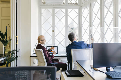 Geschäftsleute schauen im Büro auf ihr Smartphone - JRFF04832