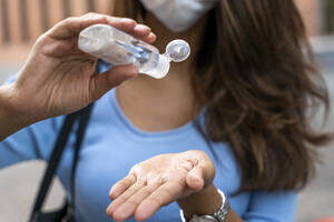 Businesswoman pouring sanitizer on hand during pandemic - AFVF07471