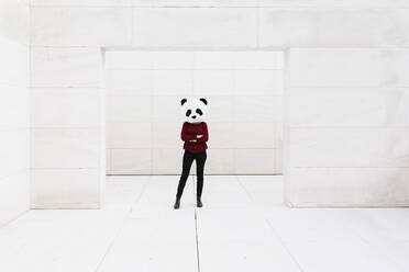 Frau mit Pandamaske steht an der Tür vor einer weißen Wand - XLGF00750