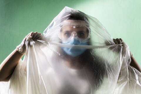 Woman wearing protective face mask covered in plastic during coronavirus stock photo
