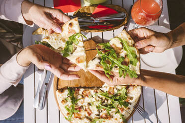 Reife Freundinnen essen Pizza am Tisch im Restaurant - VYF00204