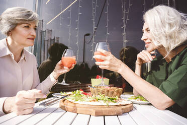 Schöne reife Frauen mit Getränk und Pizza beim Sitzen im Restaurant - VYF00207