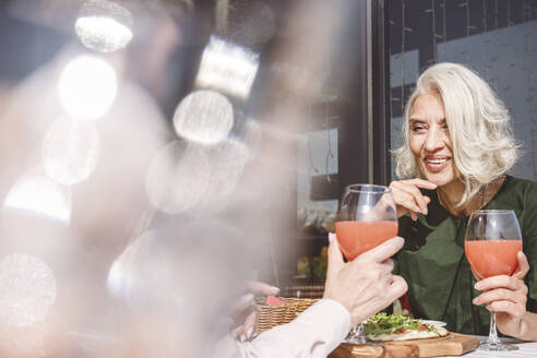 Freunde unterhalten sich beim Essen und Trinken im Restaurant - VYF00209