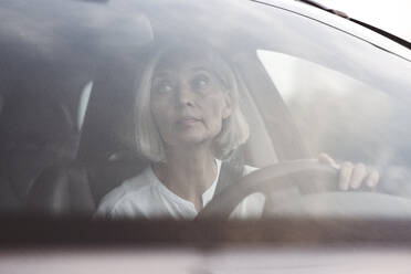 Businesswoman looking away while driving car in city - VYF00277