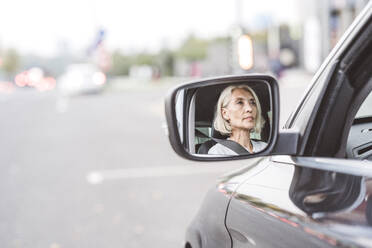 Reflexion der Geschäftsfrau auf dem Seitenspiegel beim Autofahren in der Stadt - VYF00281