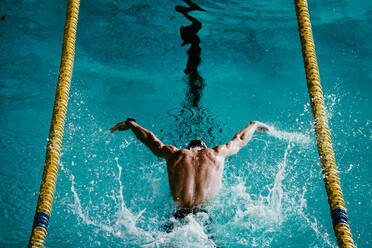 Männlicher Schwimmer beim Schmetterlingsschwimmen im Schwimmbad - EBBF01296