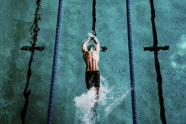 Männlicher Profischwimmer beim Rückenschwimmen im Schwimmbad - EBBF01298