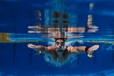 Professioneller männlicher Schwimmer übt Unterwasserschwimmen im Pool - EBBF01311