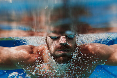 Nahaufnahme eines Schwimmers, der im Schwimmbad unter Wasser taucht - EBBF01312