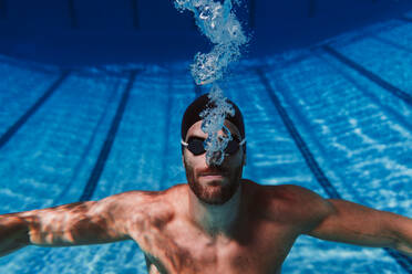 Professioneller junger männlicher Schwimmer beim Unterwasserschwimmen - EBBF01313