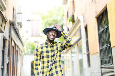 Smiling african man wearing hat in city - PGF00174