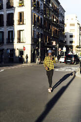 Selbstbewusster afrikanischer Mann benutzt sein Smartphone beim Spaziergang in der Stadt - PGF00185