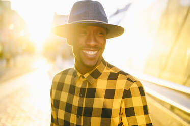 Smiling african man standing in city during sunset - PGF00194