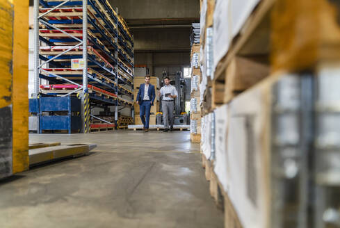 Geschäftsleute diskutieren bei einem Spaziergang in einer Fabrik - DIGF13049