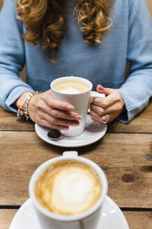Frau trinkt Kaffee am Tisch - JMPF00510