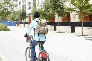 Man with backpack commuting on bicycle in city - PMF01507