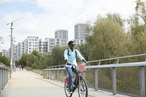 Smiling man commuting on bicycle in city stock photo