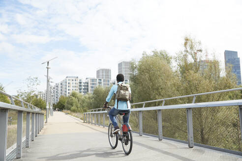 Älterer Mann, der mit dem Fahrrad in der Stadt auf der Straße pendelt - PMF01515