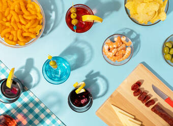 Blue table set with various snacks, appetizers and cocktails - GEMF04364